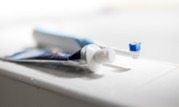 Photo of a toothbrush and toothpaste on a bathroom sink