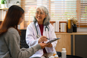 Photo of a smiling doctor with a female patient