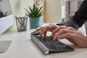 Photo of a person typing on a computer keyboard