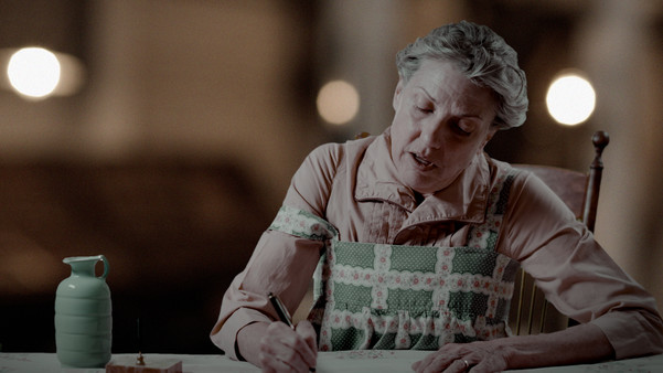 Dust to Eat promotional photo of woman playing Caroline Henderson writing letters at a table