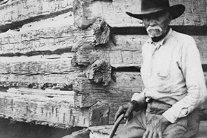 Morris Sheppard, a Freedman sitting on a porch of a log cabin
