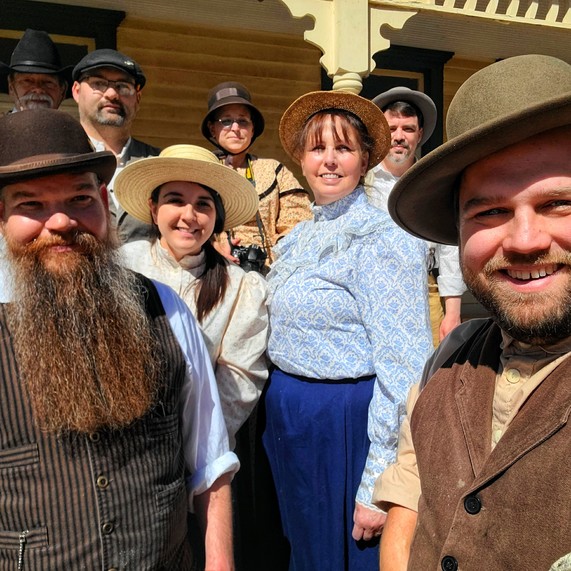 Living History reenactors stand in front of an historic home