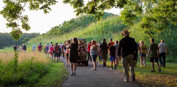 People walking down a path together and the Spiro Mounds site