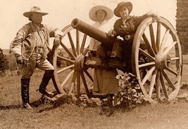 Pawnee Bill and wife May Lillie posing beside a cannon on the grounds of the Pawnee Bill Ranch