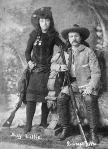 Young Western entertainers May and Gordon William Lillie posing for a portrait in western gear and hats