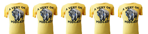 A line of A Very OK Podcast t shirts. The clothing item is yellow with the podcast logo featuring a bison with headphones