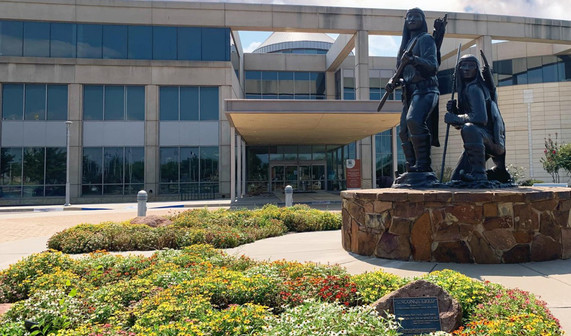 The front entrance of the Oklahoma History center and Allan Houser's sculpture depicting Apache warriors (Unconquered)