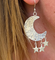 a photograph of a pair of dangle earrings with moon and stars motif
