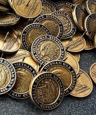 a bunch of Vietnam War–era pins are collected on a table top