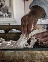A man's hands working with dough for multiple loaves prepared at Fort Gibson's Bake Day