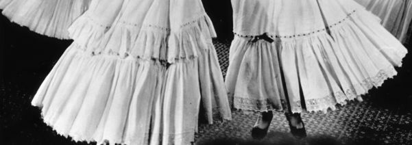 a cropped photograph of women dancing in their petticoats in a the film Oklahoma!