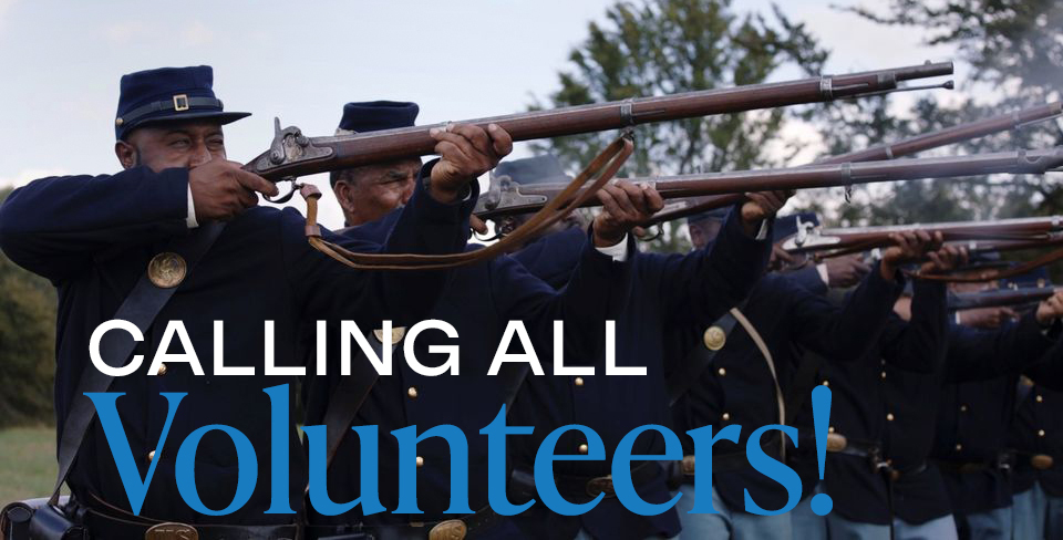 a photograph depicting reenactors of the First Kansas Regimaent pointing muskets in a formation and the words Calling all Volunteers!