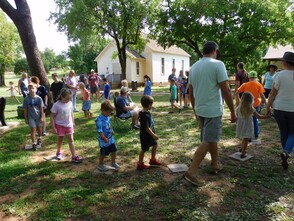 Families play a game walking in a circle near the Rose Hill school in Perry during Family Fun Day held in the summer