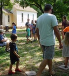 Families play a game walking in a circle near the Rose Hill school in Perry during Family Fun Day held in the summer