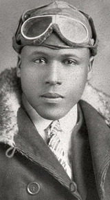 A portrait of James H. Banning with aviator leather helmet and goggles with a fur-collared coat and a shirt and tie