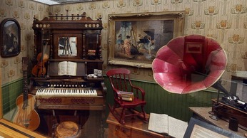 A display of musical instruments, including a pump organ and a phonograph player on exhibit at the Museum of the Western Prairie