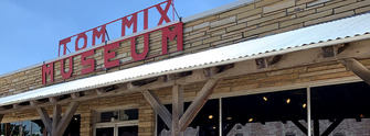The front of the Tom Mix Museum building with sign in red lettering