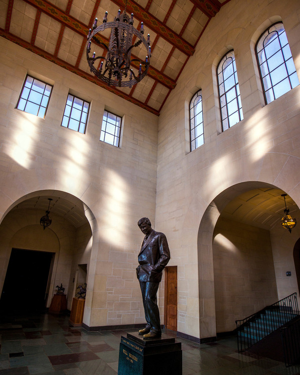 The memorial statue located in Will Rogers Memorial Museum vestibule. The photograph depicts the statue and windows of the structure above.