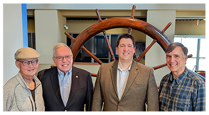 Bob Blackburn, Jack Baker, Trait Thompson and Lindsay Robertson pictured at the History Center with the USS Oklahoma wheel