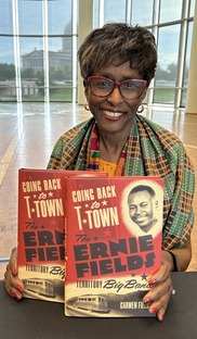 Carmen Fields with her book title sitting in the Freat Devon Hall at the Oklahoma History Center