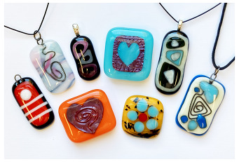 a collection of colorful fused glass pendants attached to keychains and pendant strings