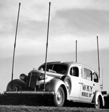 A vehicle used in 1950 to broadcast the WKY news. The automobile has 4 poles at each wheel hub.