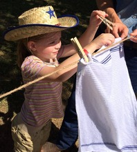 a Wild West camper hanging laundry on the line after learning to use a washboard.