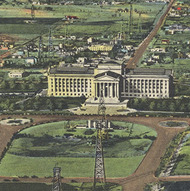 A colorized postcard image of the Oklahoma State Capitol and Grounds. Oil derricks are surrounding the Capitol building