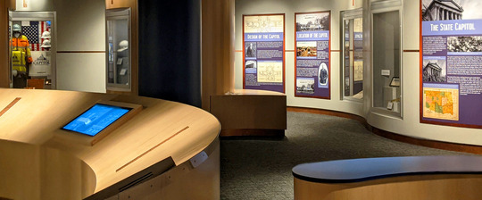 Capitol Museum panoramic banner depicting touch screens, exhibits, and wall text.