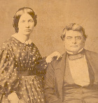Robert M. Jones and Susan Colbert. An historic photo. Jones is seated and Colbert is wearing a polkadot dress.