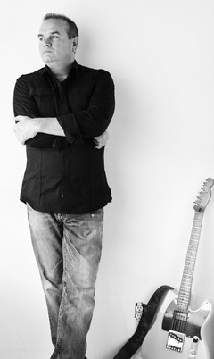 Travis Kidd singer songwriter posing with guitar