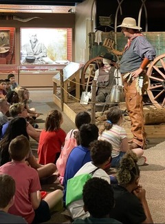 Jason Harris speaks to a group of schoolchildren at The Chisholm museum in Kingfisher. Exhibits of the Wild West are seen around them