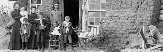 A family standing outside a dug out home in rural Oklahoma