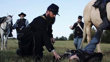 An image of the Documentary from the Battle of Honey Springs featuring Brigadier General Douglas H. Cooper attending a fallen soldier