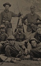 Union Soldiers gathered as a group in three rows, commanding officer to the left, and a tree in the background