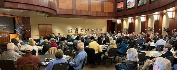 People gathered at round tables in the event center at OHC for the 2023 Oklahoma History Symposium listening to speaker Dr. Karlos Hill. 