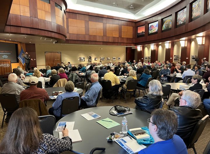 People gathered at round tables in the event center at OHC for the 2023 Oklahoma History Symposium listening to speaker Dr. Karlos Hill. 