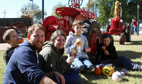 A Family having a picnic by a tractor on Family Farm Day at Cherokee Strip Heritage Center Museum.