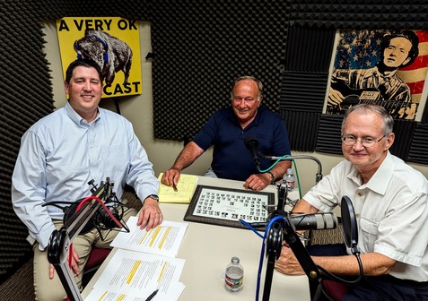 Trait Thompson, Cal Hobson, and Bob Blackburn are seated around a table in a recording room. Mics are seen on the table.