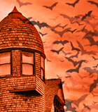 Horizon Hill with an orange coloration of the historic home and bats flying in the background