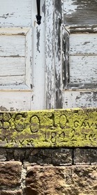 An engraving dated 1842 in the stonework of the Fort Gibson barracks. The carving is partially covered by moss.