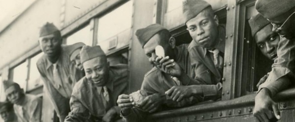 Black soldiers receiving refreshment through bus windows