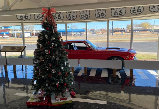 The Route 66 Museum with a Christmas tree and Red Mustang on view in the main windows.