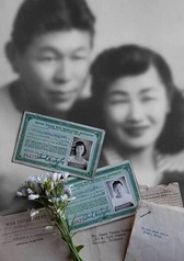 A black and white photograph of a couple and their War Department documents and ids from a Japanese Internment Camp