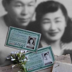A black and white photograph of a couple and their War Department documents and ids from a Japanese Internment Camp