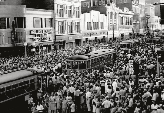 People celebrating the end of World War II in Oklahoma City in 1945. Sailors, soldiers, and citizens crowd the streets, engulfing trollies