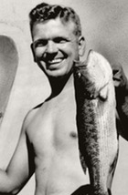 George Nigh on a fishing trip to Lake Murray, holds up a large bass and water skis