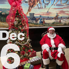 Santa Clause sitting in a chair with a Christmas tree to his right, and the Will Rogers Memorial Museum mural behind.