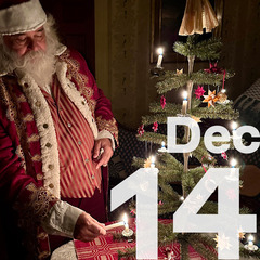 Santa Claus lights a candle for a small Christmas fir tree. He is dressed in an elaborate Christmas suit made of velvet.