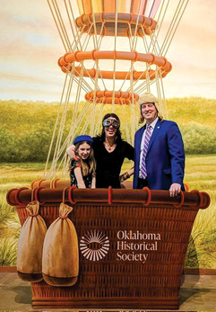 A family gathers in the basket of a hot air balloon for a photo op.